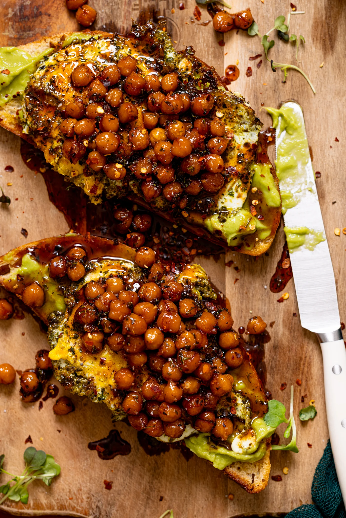 Image of Pesto Egg Avocado Toast on a cutting board with a knife.